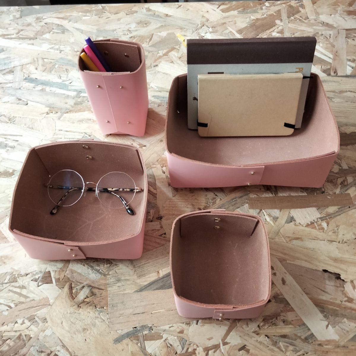 Trois panières et un pot à crayons en cuir rose