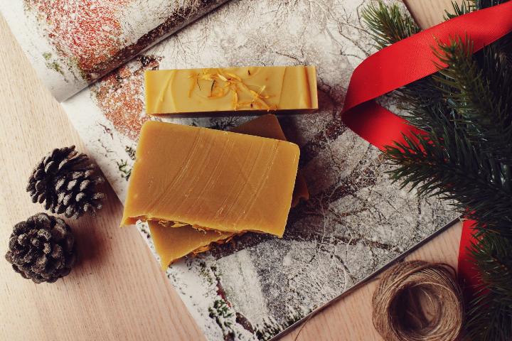 Savons sur une table avec une décoration Noël, sapin, ruban rouge et pomme de pin